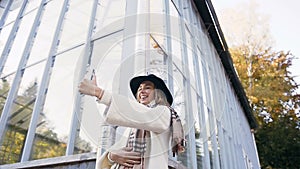 Handsome young woman making selfie on her smart phone on the park background.