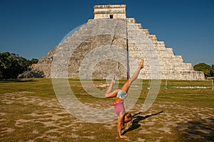 Handstand in front of famous Kukulkan pyramid in Chichen Itza, Mexico