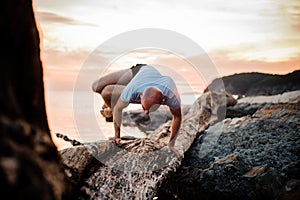 Handstand yoga pose by man on the beach near the ocean