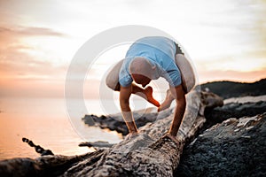 Handstand yoga pose by man on the beach near the ocean