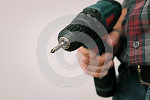 Handworker working with an electric screwdriver. Carpenter fixing wooden construction with portable drill