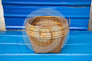 Handwoven bamboo basket with blue metal background, storage basket