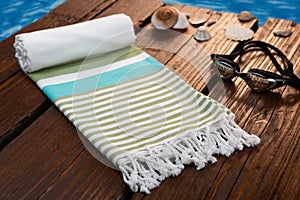 Handwoven blue hammam Turkish cotton towel on dark wooden bridge