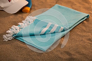Handwoven hammam Turkish cotton towel on the sandy beach