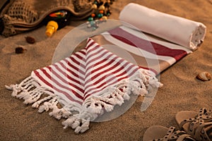 Handwoven hammam Turkish cotton towel on sandy beach photo