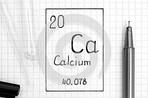 Handwriting chemical element Calcium Ca with black pen, test tube and pipette