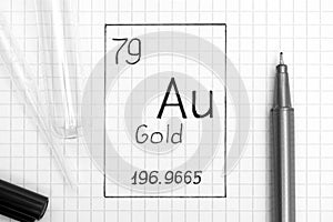 Handwriting chemical element Gold Au with black pen, test tube and pipette. Close-up