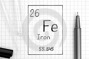 Handwriting chemical element Iron Fe with black pen, test tube and pipette