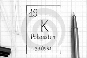 Handwriting chemical element Potassium K with black pen, test tube and pipette