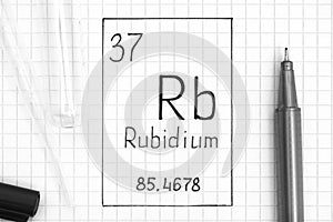 Handwriting chemical element Rubidium Rb with black pen, test tube and pipette