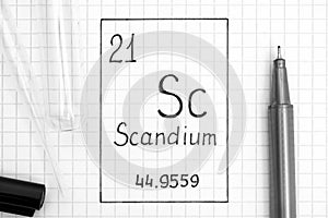 Handwriting chemical element Scandium Sc with black pen, test tube and pipette