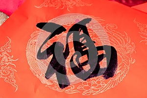 The Handwriting Chinese blessing Fu on the red paper with Chinese dragon pattern background.