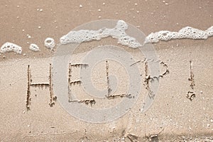 Handwriting message word help at sea beach sand