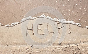 Handwriting message word help at sea beach sand