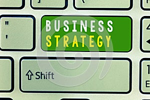 Handwriting text Business Strategy. Concept meaning Management game plan to achieve desired goal or objective