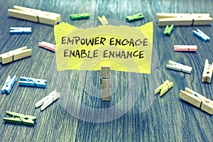 Handwriting text Empower Engage Enable Enhance. Concept meaning Empowerment Leadership Motivation Engagement Paperclip hold writte photo