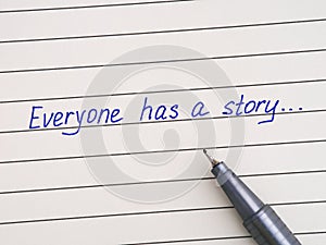 Handwriting text Everyone Has a Story on a lined paper with a pen