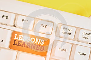 Handwriting text Lessons Learned. Concept meaning the knowledge or understanding gained by experience White pc keyboard