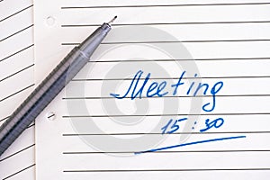 Handwriting text Meeting 15 30  on lined paper with pen