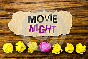 Handwriting text Movie Night. Concept for Wathing Movies Written on sticky note paper reminder, wooden background with sticky,
