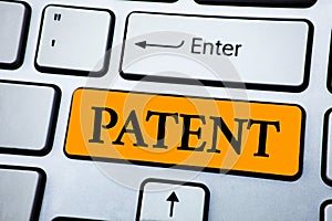 Handwriting text Patent. Concept meaning License that gives rights for using selling making a product written on Orange Key Button