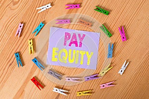 Handwriting text Pay Equity. Concept meaning eliminating sex and race discrimination in wage systems Colored clothespin