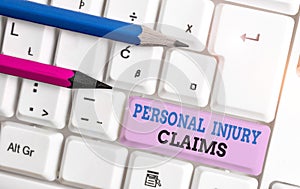 Handwriting text Personal Injury Claims. Concept meaning being hurt or injured inside work environment White pc keyboard