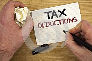Handwriting text Tax Deductions. Concept meaning Reduction on taxes Investment Savings Money Returns Text two words white paper no