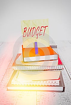 Handwriting text writing Budget. Concept meaning an estimate of income and expenditure for a set period of time pile stacked books