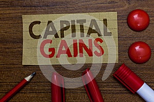 Handwriting text writing Capital Gains. Concept meaning Bonds Shares Stocks Profit Income Tax Investment Funds Paperboard markers