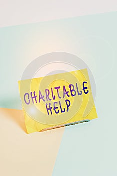 Handwriting text writing Charitable Help. Concept meaning system of giving money or help free to those who are in need Paper