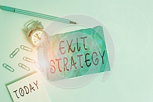 Handwriting text writing Exit Strategy. Concept meaning Extricating oneself from a situation that is become difficult Alarm clock photo