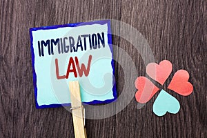 Handwriting text writing Immigration Law. Concept meaning National Regulations for immigrants Deportation rules written on Sticky
