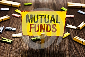 Handwriting text writing Mutual Funds. Concept meaning An investment program funded by shareholders Individual Stocks Clothespin h