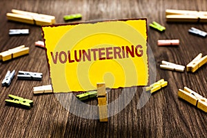 Handwriting text writing Volunteering. Concept meaning Provide services for no financial gain Willingly Oblige Clothespin holding