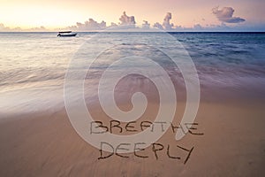 Handwritten Breathe deeply on sandy beach