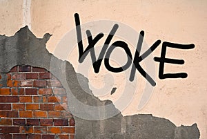 Handwritten graffiti Woke sprayed on the wall, anarchist aesthetics photo
