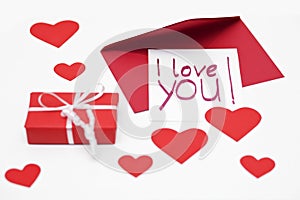 Handwritten I love you - note for Valentine`s Day and a red parcel.