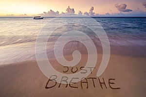 Handwritten Just breathe on sandy beach photo