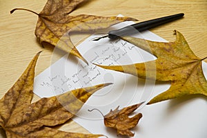 Handwritten love letter with autumn leaves in background