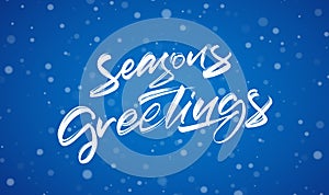 Handwritten modern brush typy lettering of Season`s Greetings on blue winter background