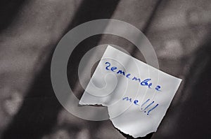 Handwritten note Remember Me on a white piece of paper