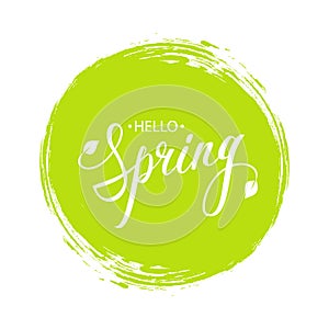Handwritten phrase Hello Spring with leaves and green circle brush stroke background. photo