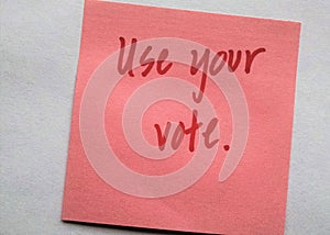 Handwritten red letters on plain background `Use your vote`