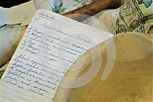 Handwritten salad recipe with dishtowel and antique mortar pestle