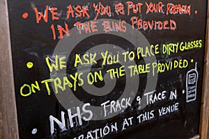 A handwritten sign at a pub including a notice about NHS track and trace as the covid lockdown eases in the UK photo