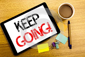 Handwritten text caption showing Keep Going. Business concept writing for Go Moving Forward Letting Written on tablet laptop, wood