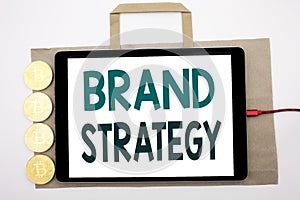 Handwritten text showing Brand Strategy. Business concept writing for Marketing Idea Plan Written on shopping bag and tablet with