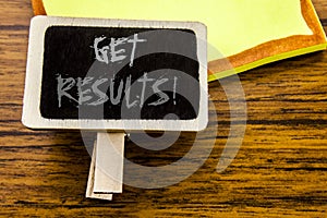 Handwritten text showing Get Results. Business concept for Achieve Result written on announcement board on the wooden wood backgro