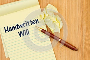 Handwritten Wills message on a notepad with crumpled paper and pen on wood desk